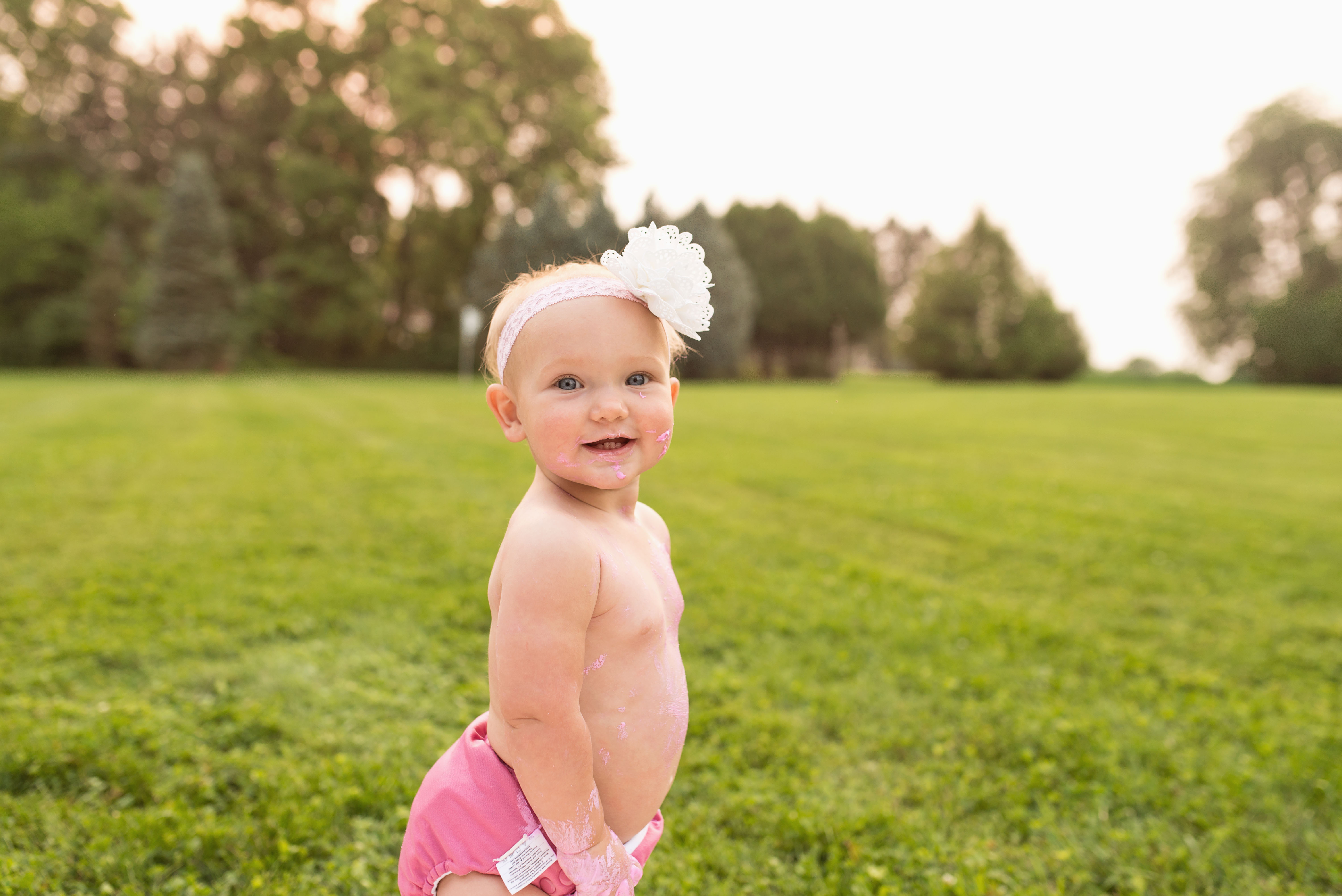 A baby smiles during her cake smash session in Cedar Rapids