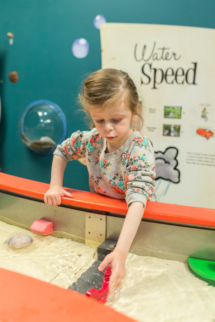 A little girl plays with a water table at Wickiup Hill Learning Center - kids' activities in Cedar Rapids