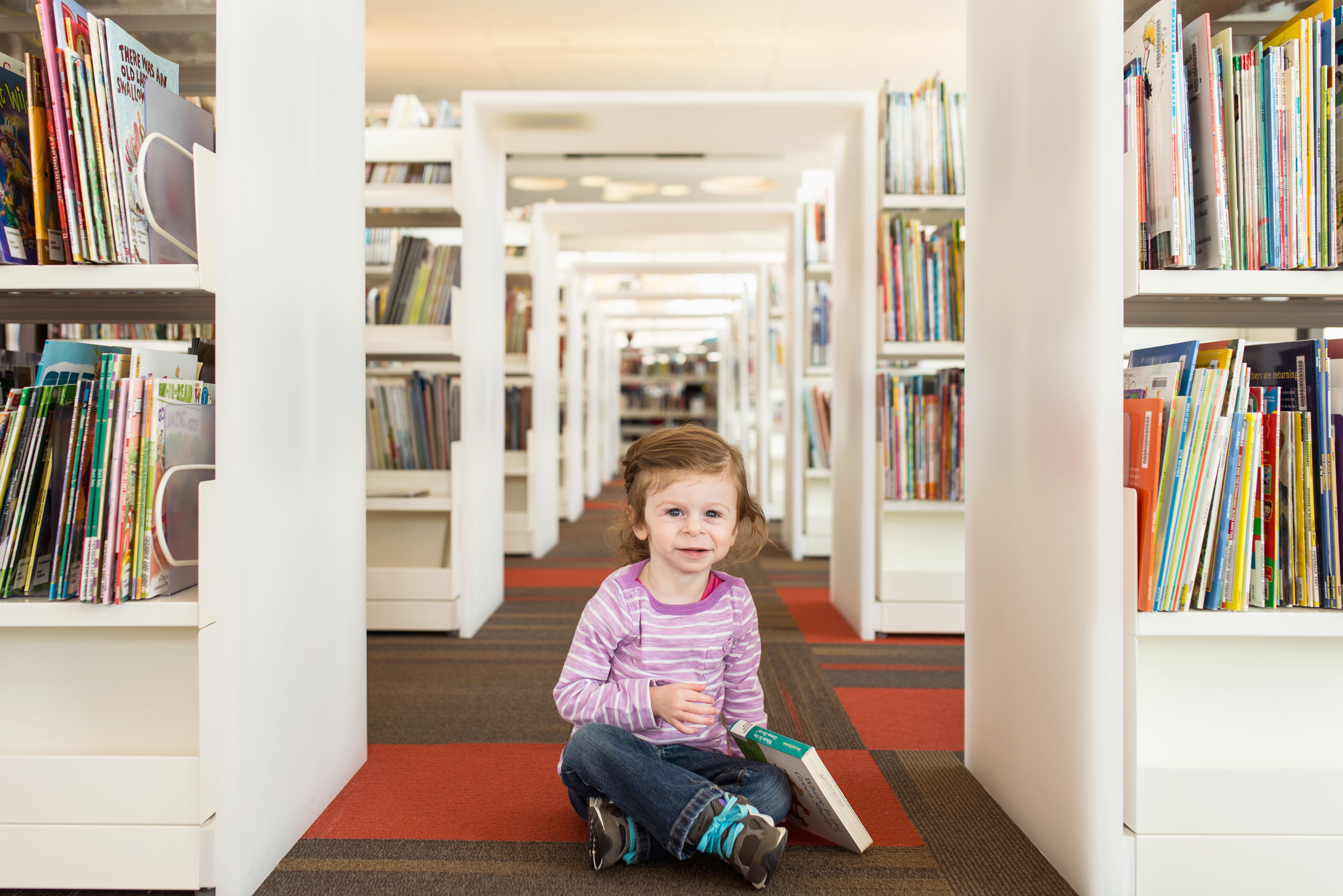 A little girl reads at the Cedar Rapids Public Library