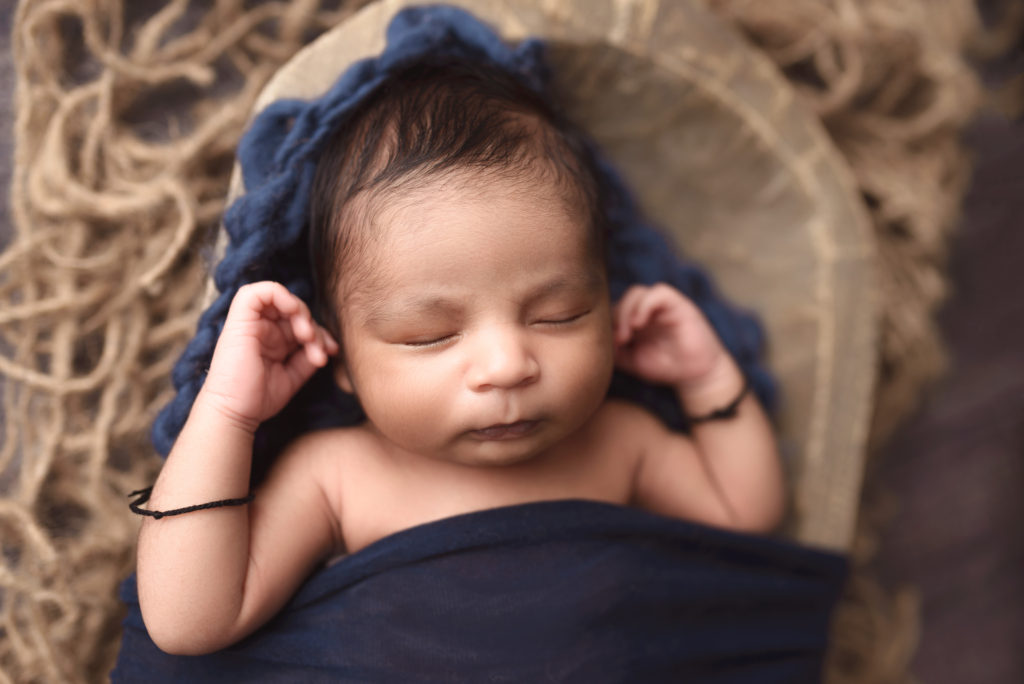 A sweet baby boy sleeps during his newborn photo session in Cedar Rapids