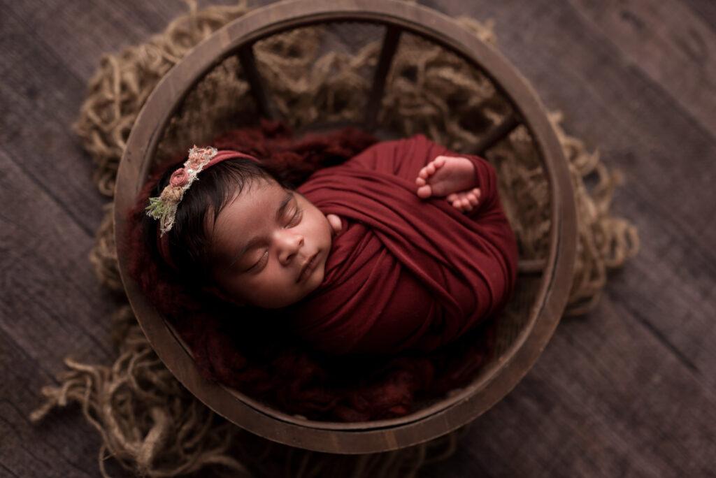 a newborn baby girl sleeps during her photographer session in Cedar Rapids