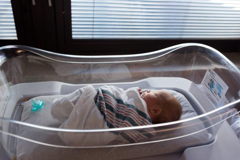 A baby sleeps in a hospital bassinet during his fresh 48 newborn session in Iowa city, baby proofing
