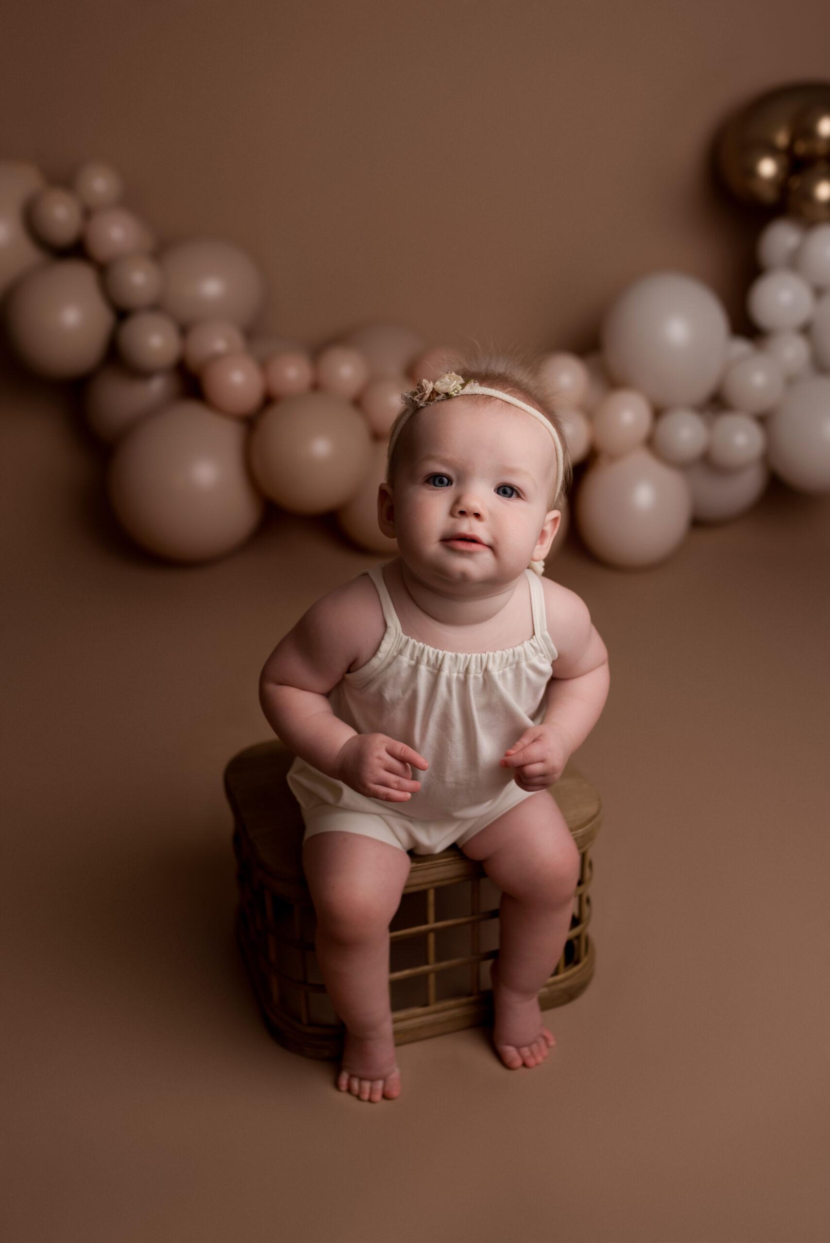 A one year old baby girl sits for her milestone photos on her birthday in Cedar Rapids