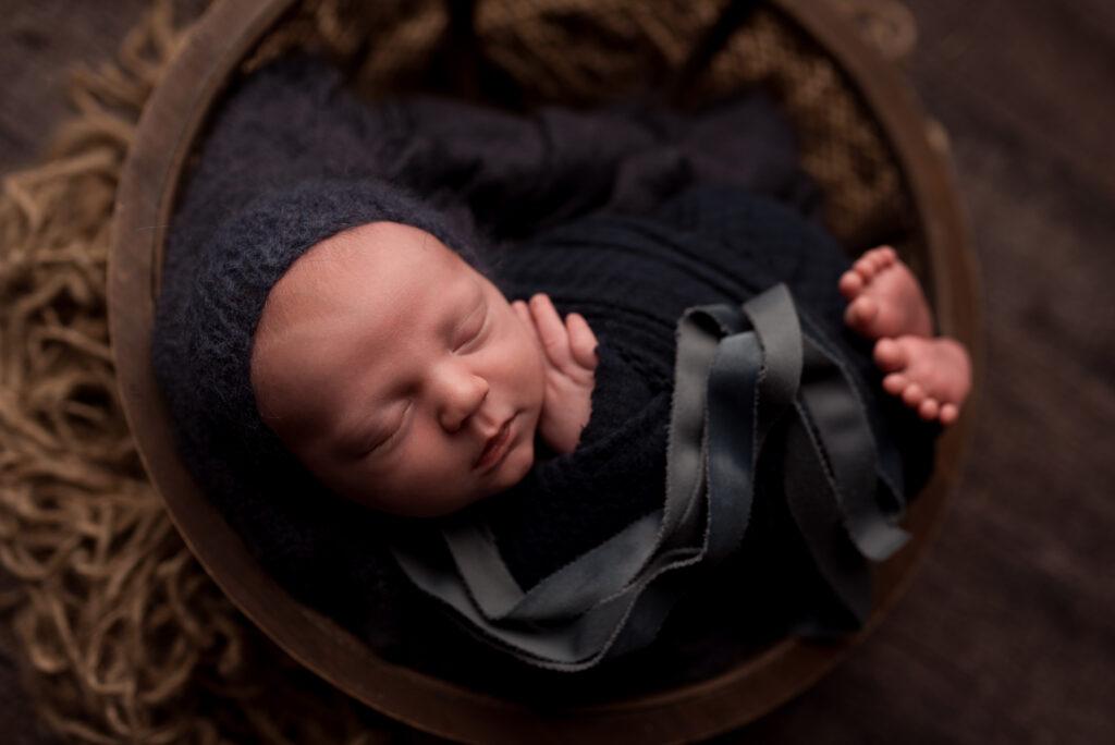 A newborn baby boy sleeps during his photography session in Cedar Rapids